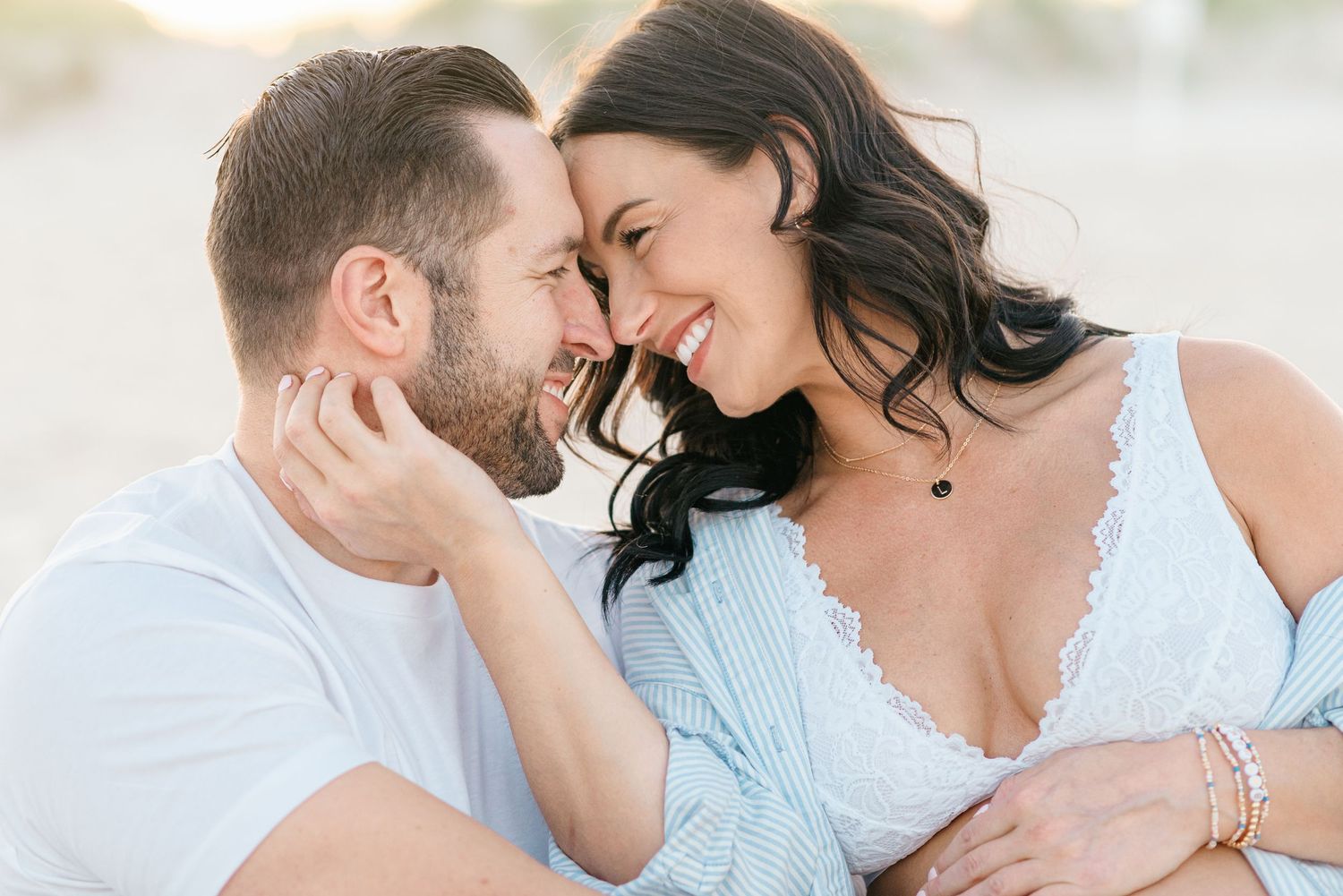 Close of of husband and expecting pregnant wife during a beach session capturing maternity images at the jersey shore.
