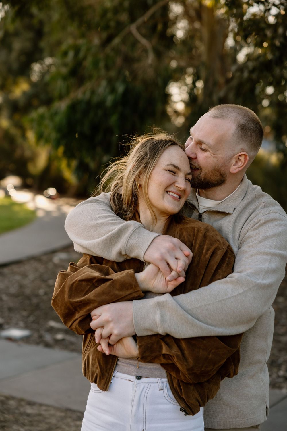 A romantic outdoor couple photoshoot showing playful moments of laughter and affection together at sunset.