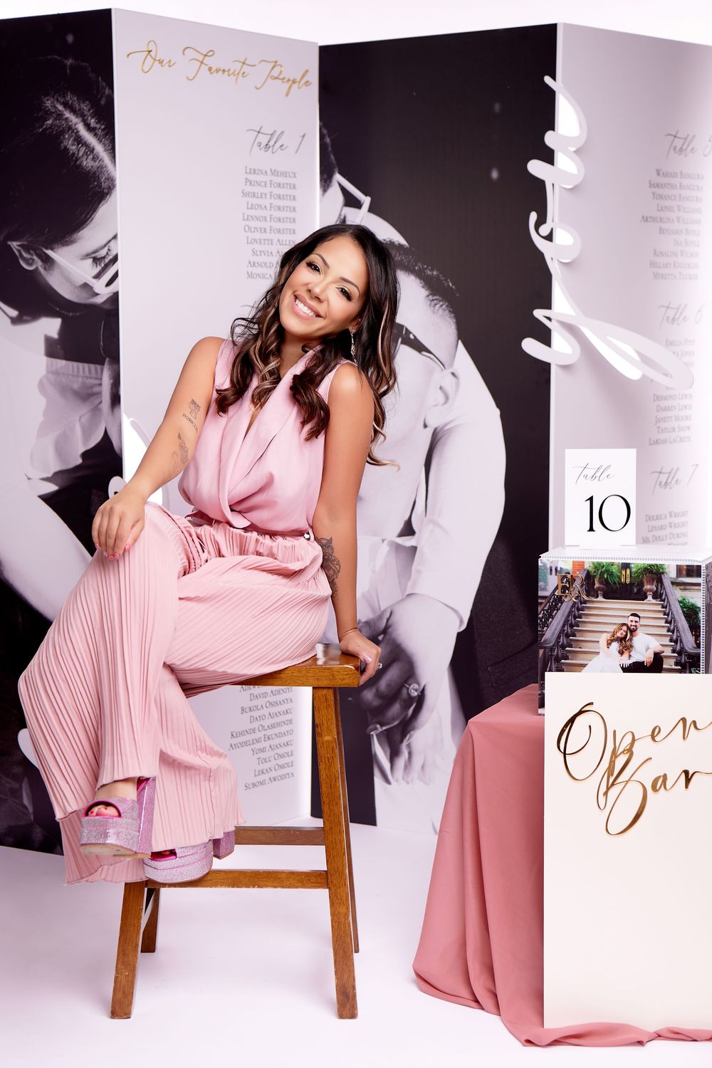 A series of photos showing someone in a flowing pink pleated dress posing elegantly on a wooden stool against a white backdrop.