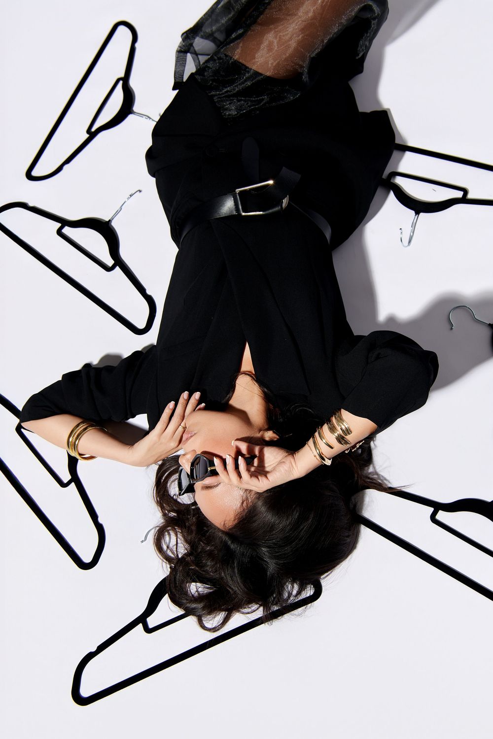 Artistic black and white fashion photo series showing a person lying on floor in dark clothing against white background. NJ branding photos