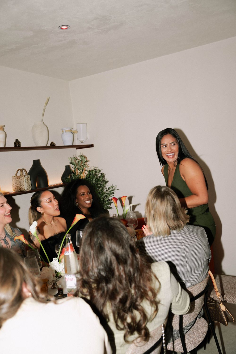 A lively gathering of friends enjoying drinks and conversation at a casual indoor party.