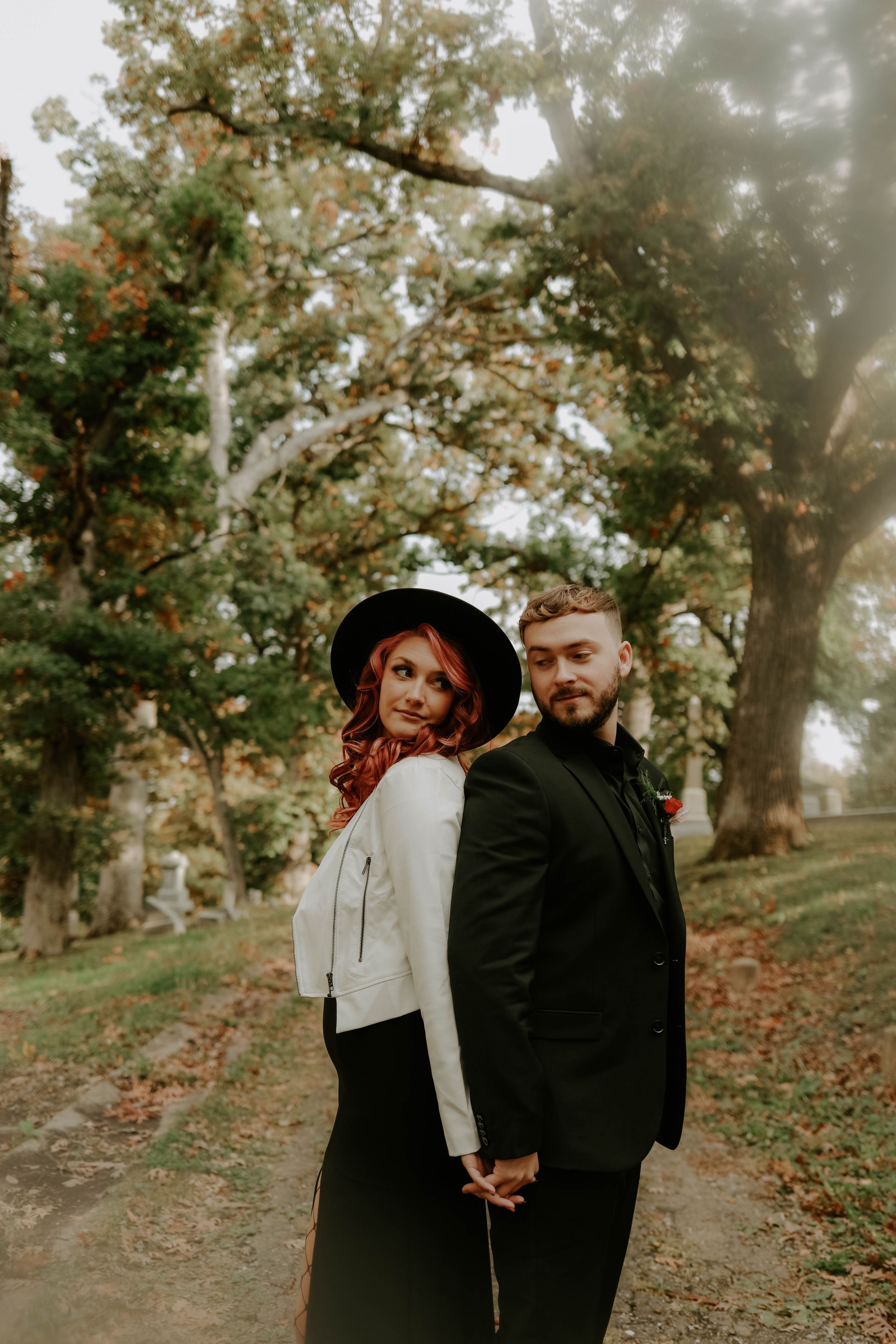 Romantic autumn photoshoot in a misty forest with a couple in black and white outfits.