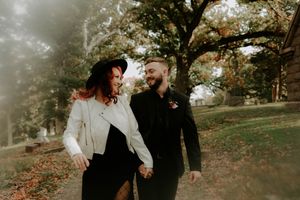 A couple shares a playful moment together in a misty autumn setting.