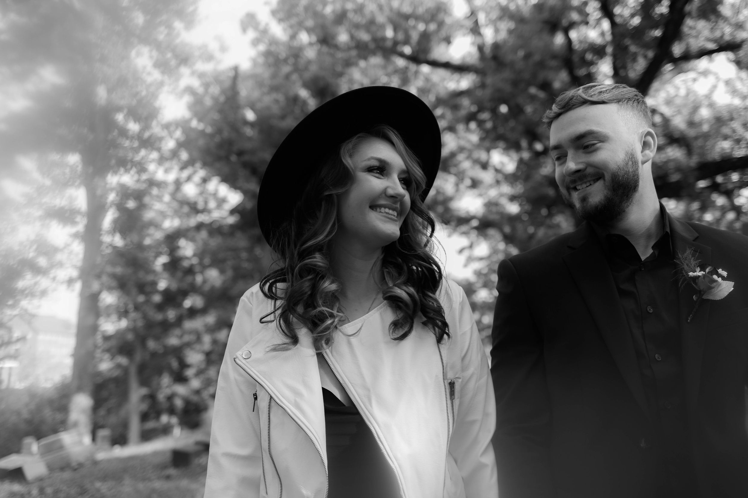 Artistic black and white portraits of a couple embracing in a foggy woodland setting.