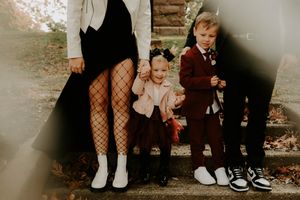 A stylish family portrait featuring fishnet tights and coordinated black and white outfits.