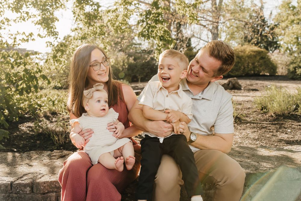 mom, dad and two kids laugh together