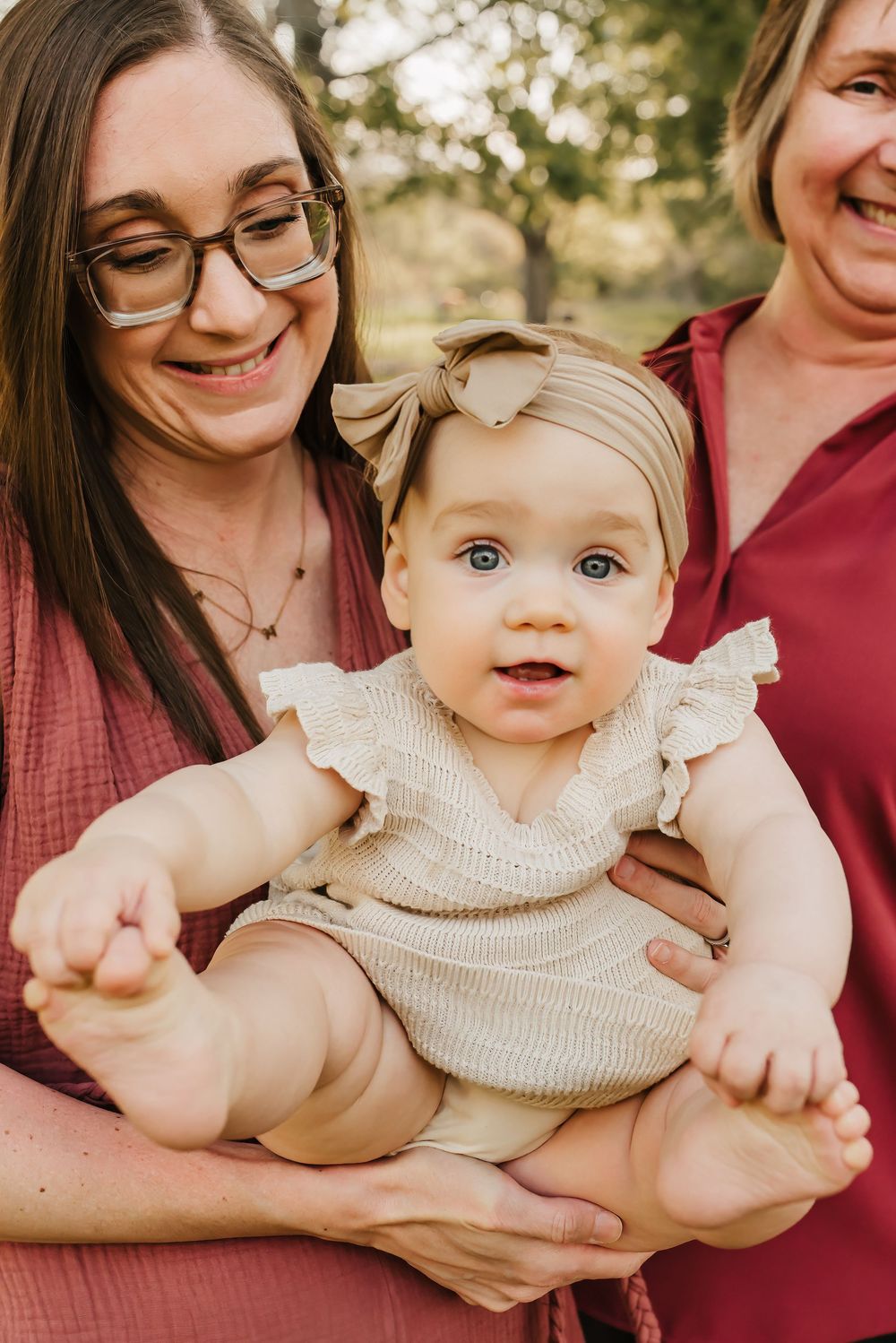 baby girl is adored by her mom and grandmother