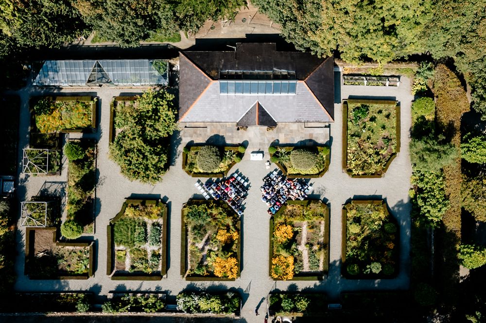 Aerial view of symmetrical formal garden with geometric pathways and manicured landscaping.