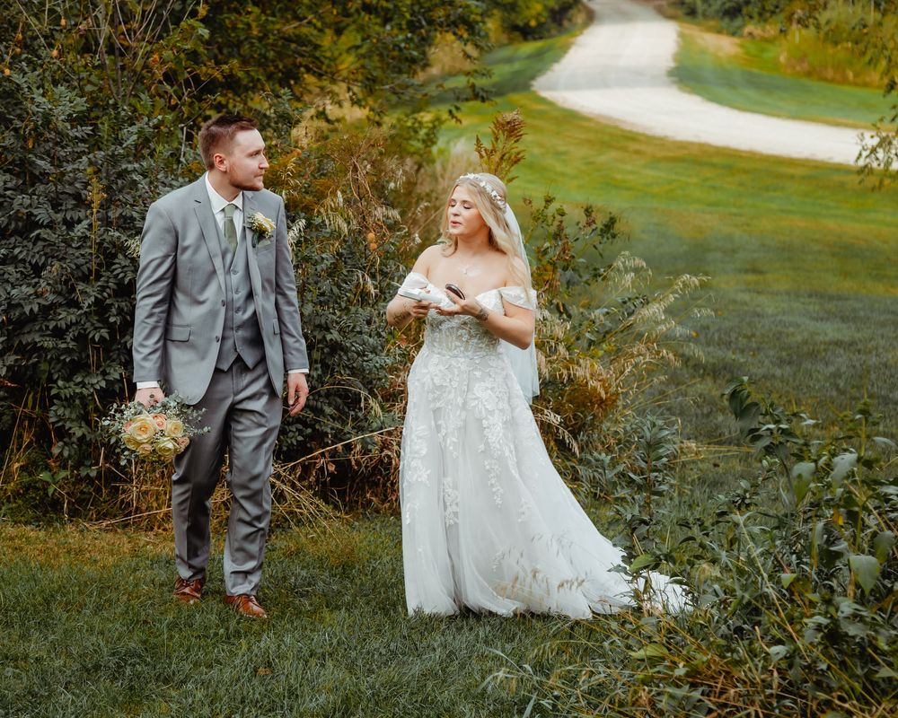 A couple in formal attire walking together along a winding garden path on their special day.
