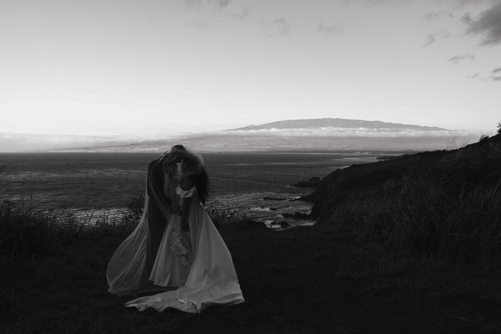 Dramatic black and white panoramic view of rolling hills and cloudy skies over a rugged landscape.