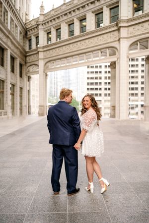 A romantic photo series showing a couple in formal attire walking along an elegant architectural corridor.