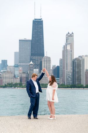 A couple shares romantic moments on North Avenue Beach with Chicago's iconic skyline as their backdrop.