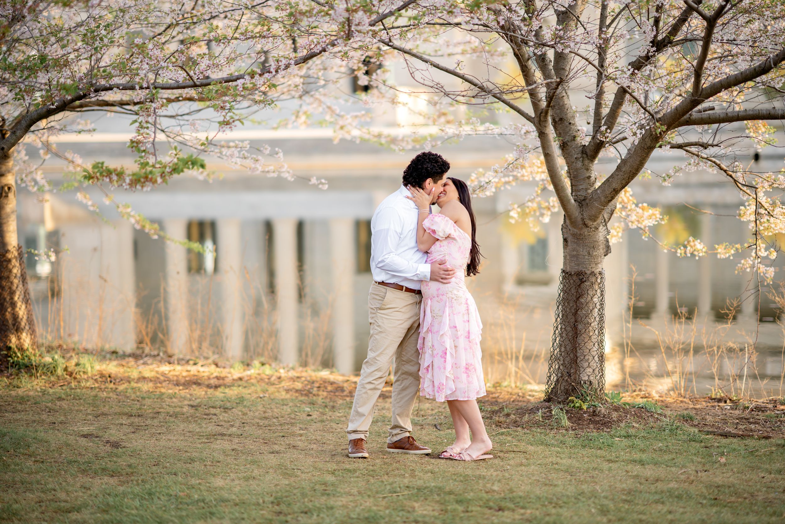 A romantic couple embraces in a dreamy outdoor setting with autumn trees and soft natural lighting.