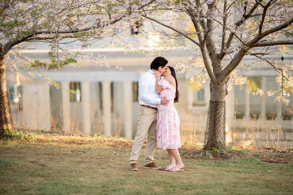 A romantic couple embraces in a dreamy outdoor setting with autumn trees and soft natural lighting.