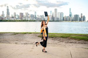 A woman in a black dress poses gracefully along the Chicago skyline at North Avenue Beach.