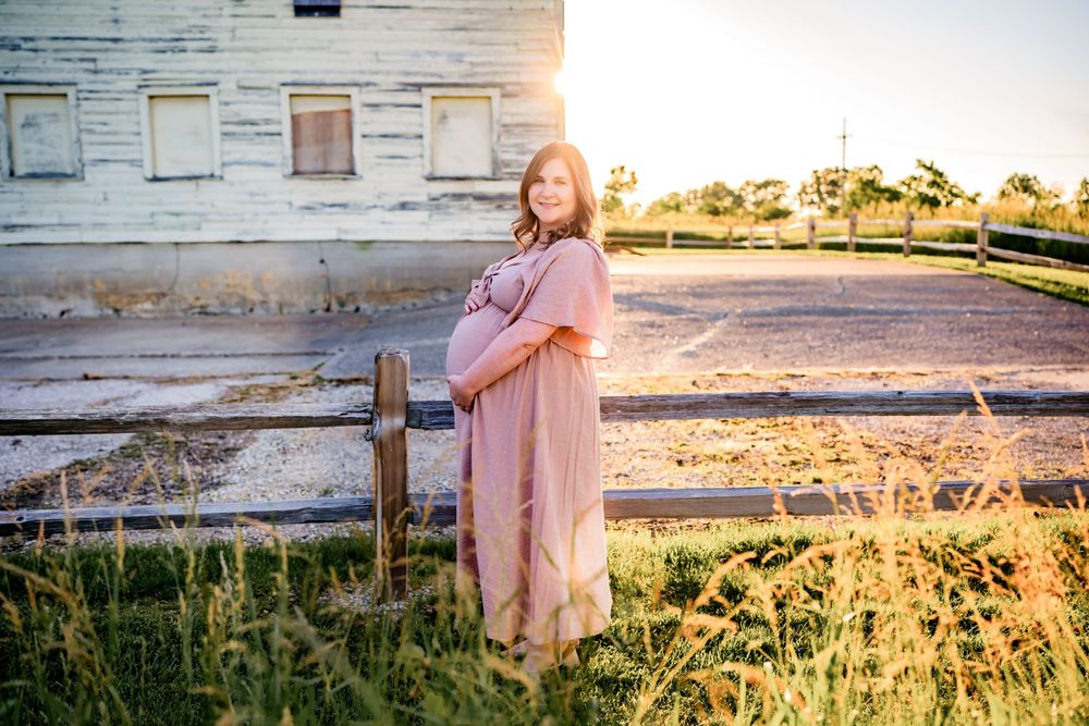Flowing maternity gown on a pregnant woman, captured during a sunset maternity session.