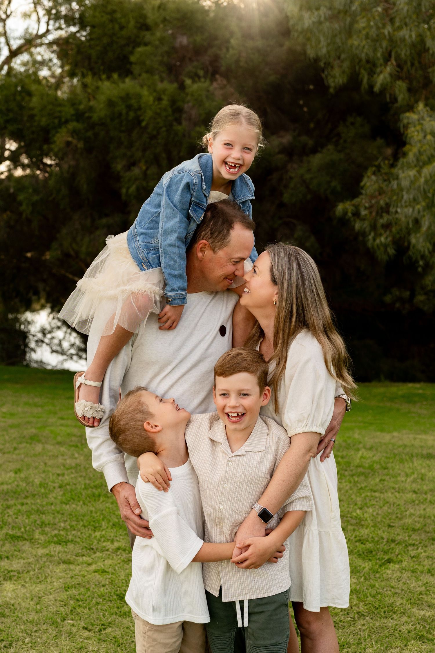 A father, mother and young child in soft golden light during an outdoors Perth family photography session