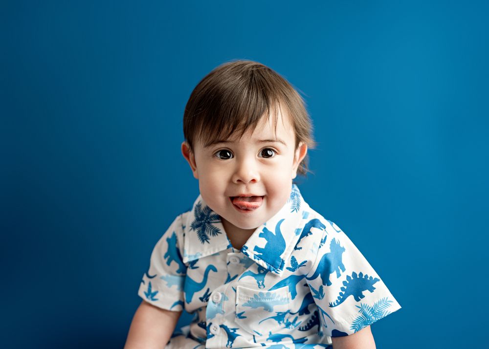 Five sequential photos show a toddler wearing a blue and white patterned shirt against a deep blue backdrop.