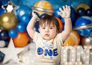 Party decorations including colorful balloons and festive decorations create a joyful first birthday celebration atmosphere.