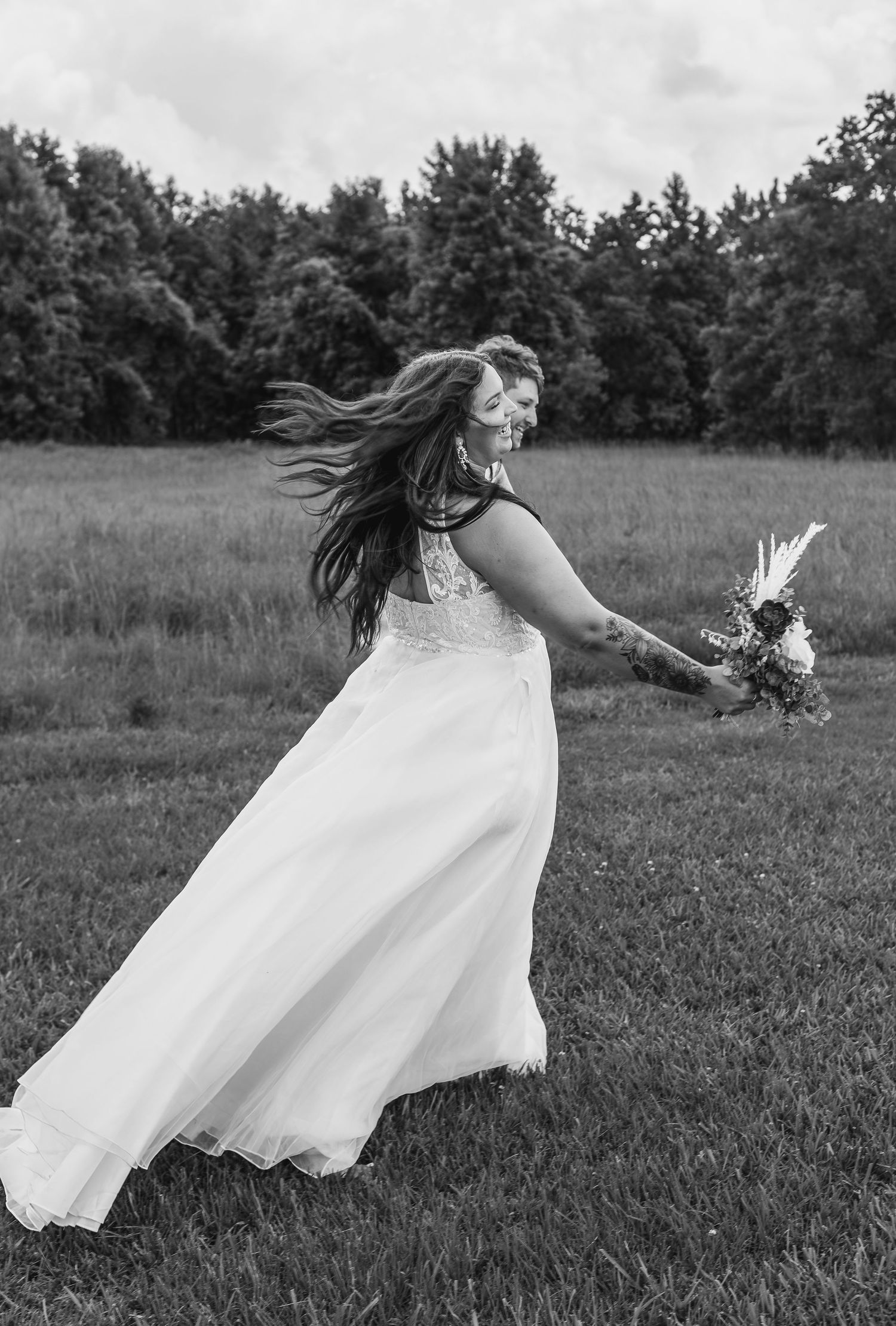 A person in a flowing white dress twirls gracefully through a field, creating a dreamy black and white motion series.