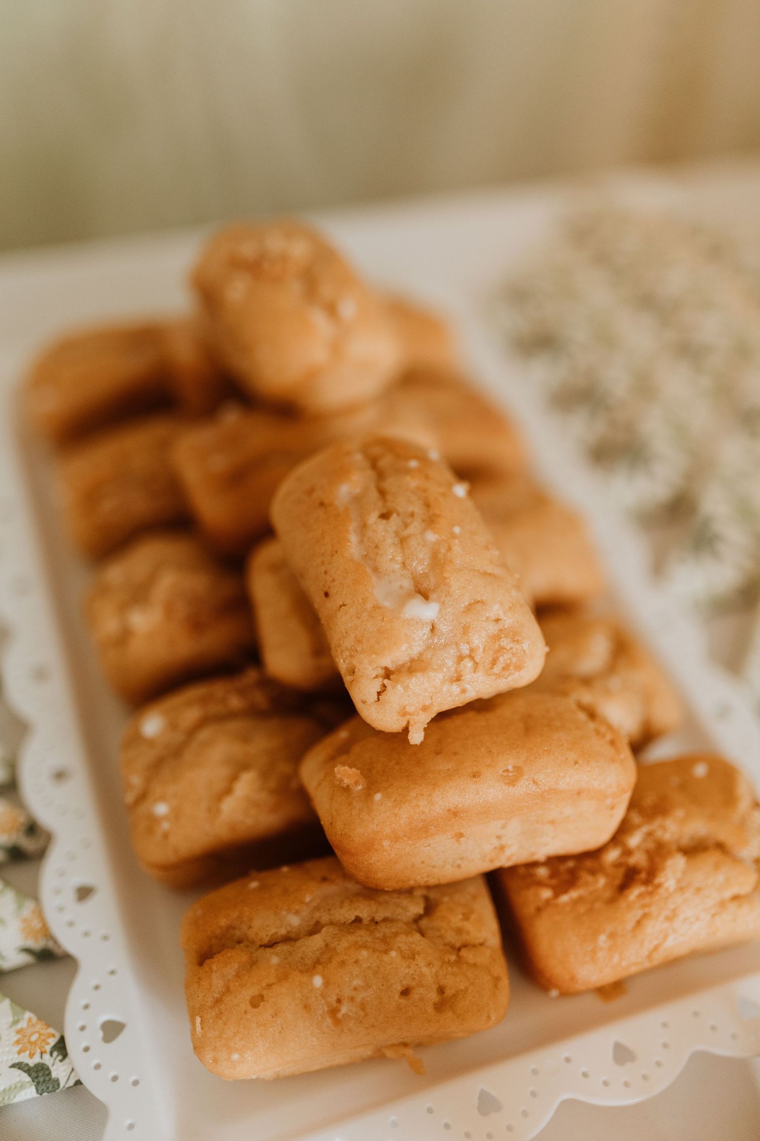 Mini loafs arranged on a white decorative plate with a delicate lace doily underneath.