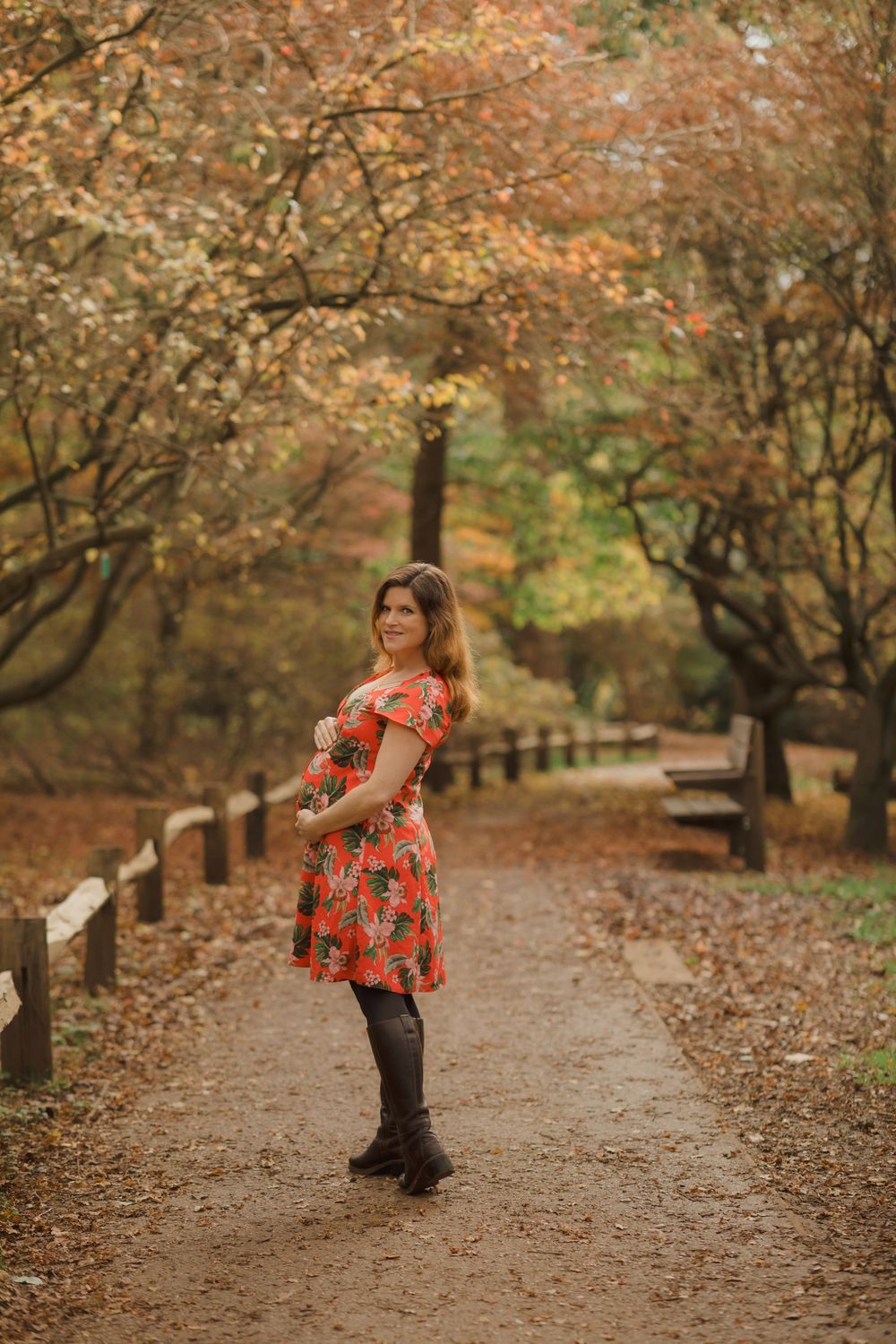 Red floral dress displayed in autumn path surrounded by fall foliage.