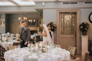 Elegantly decorated wedding reception venue with round tables, floral arrangements and warm lighting at Washingborough Hall.
