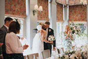 Elegant wedding reception in a bright room with floral window treatments and decorative arrangements at Washingborough Hall.