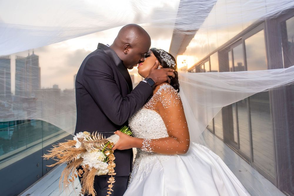 Intimate wedding portrait on rooftop with cityscape backdrop at golden hour.