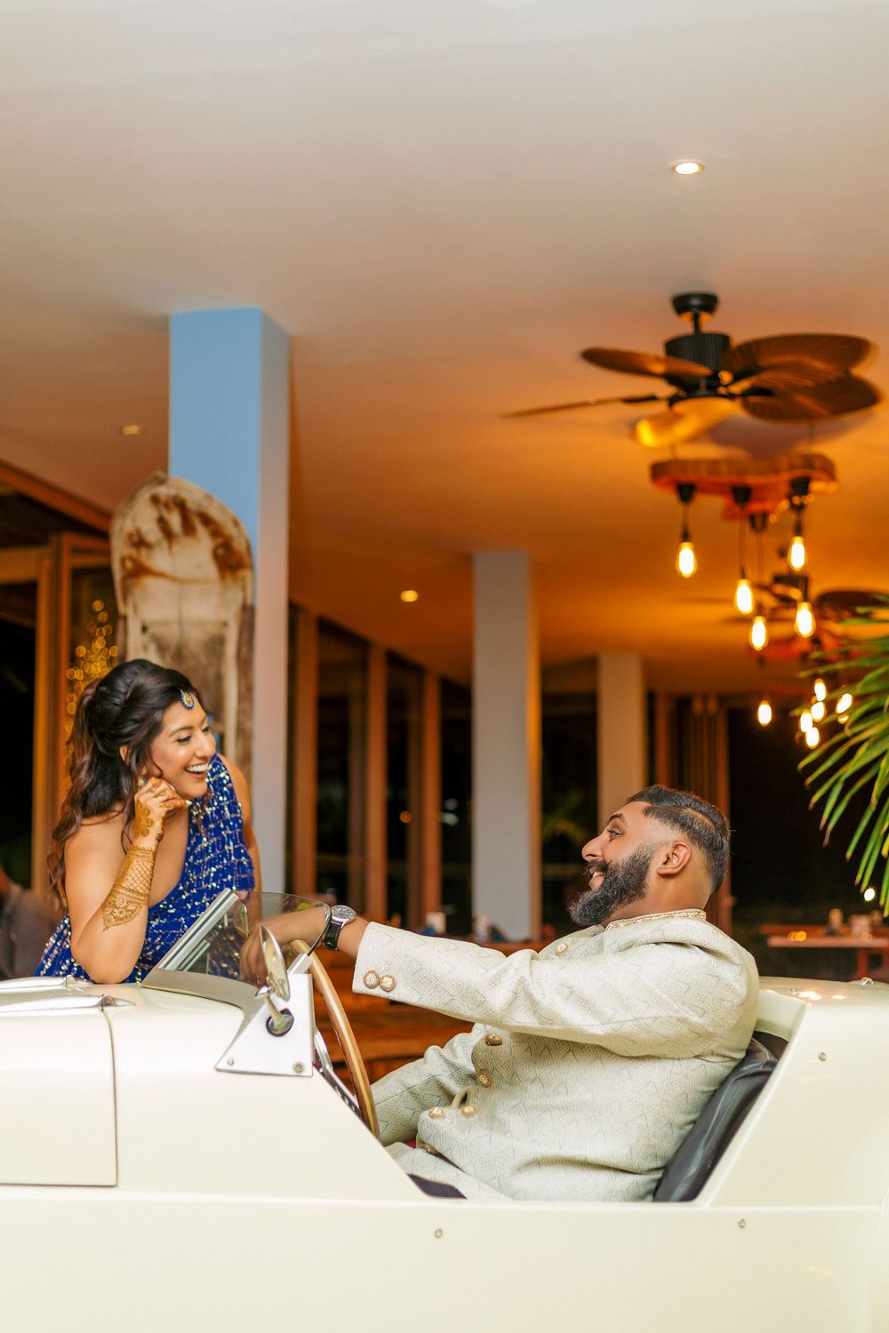 Romantic evening conversation in tropical resort setting with warm lighting.