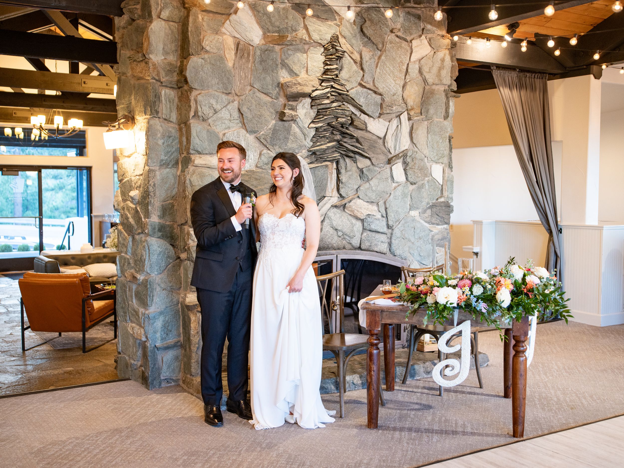 Wedding couple celebrates their special moment in a rustic stone-walled venue with elegant lighting and decor.