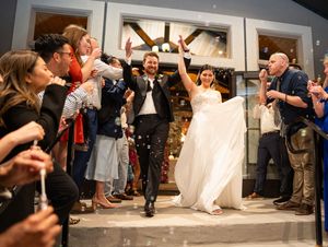 Wedding guests dance in a line during a lively reception celebration.