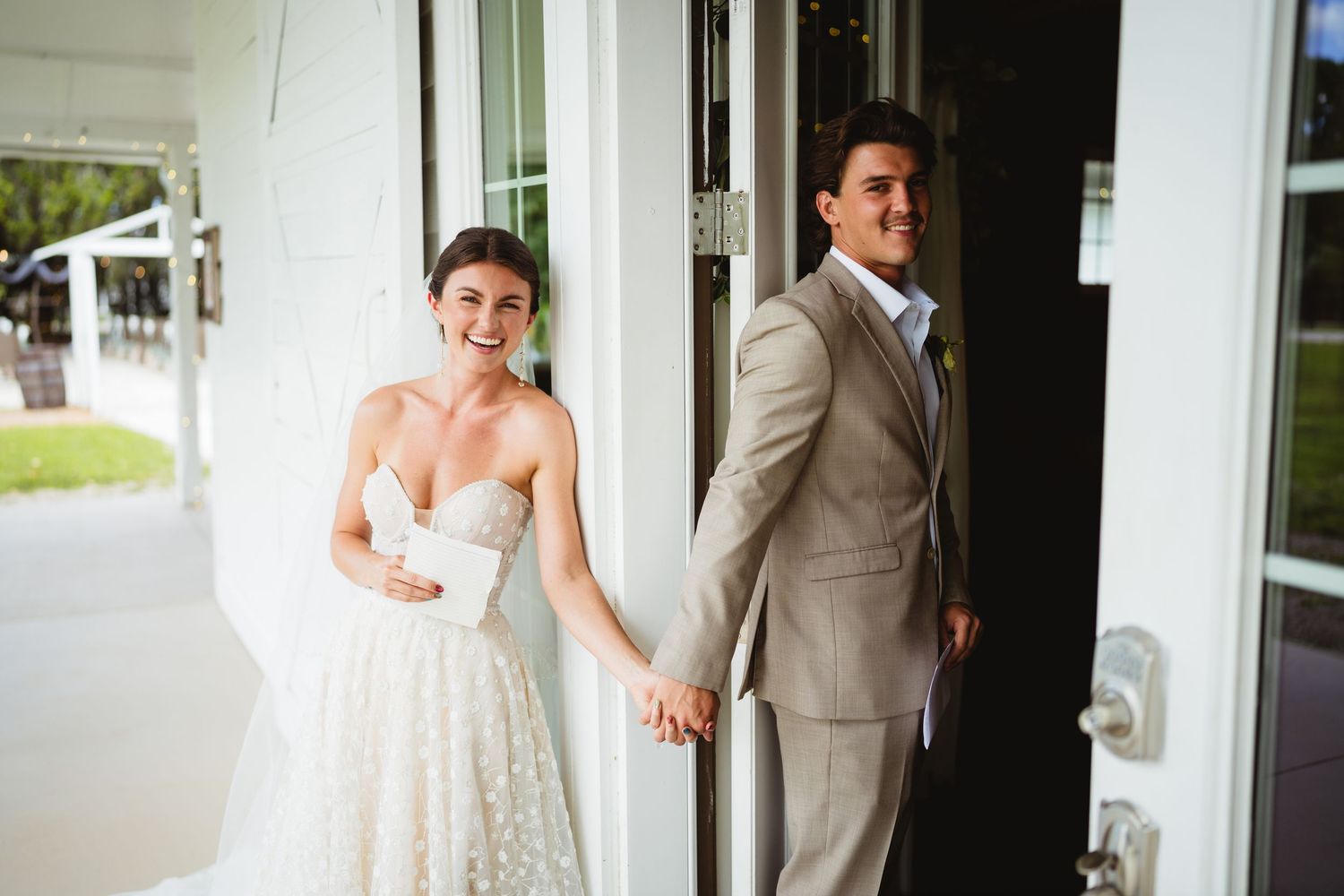 A bride and groom share a playful moment before their first look on their wedding day.