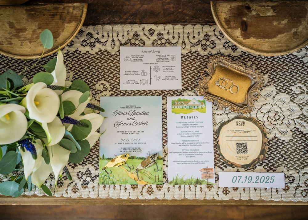 Wedding invitation suite with calla lilies and lace details displayed on vintage-style table with menu and event date.