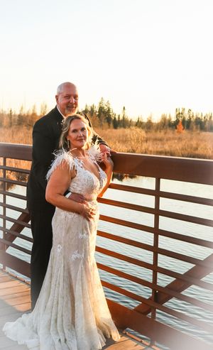 A couple embraces during sunset on a wooden deck with golden light illuminating their romantic moment.