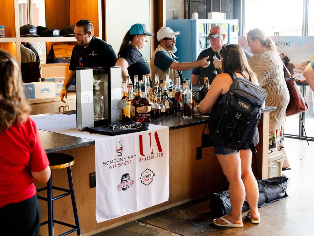 Customers line up at a modern cafe counter to place orders at wooden bar seating.