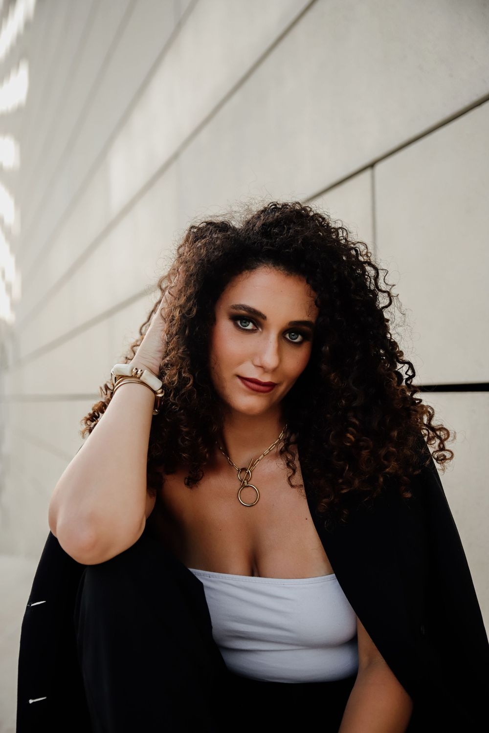 A collection of intimate fashion portraits showing a model wearing a black jacket and white top against a light backdrop.