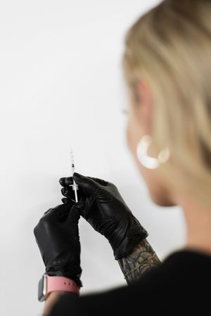 Series of hands wearing black gloves preparing cosmetic tools.