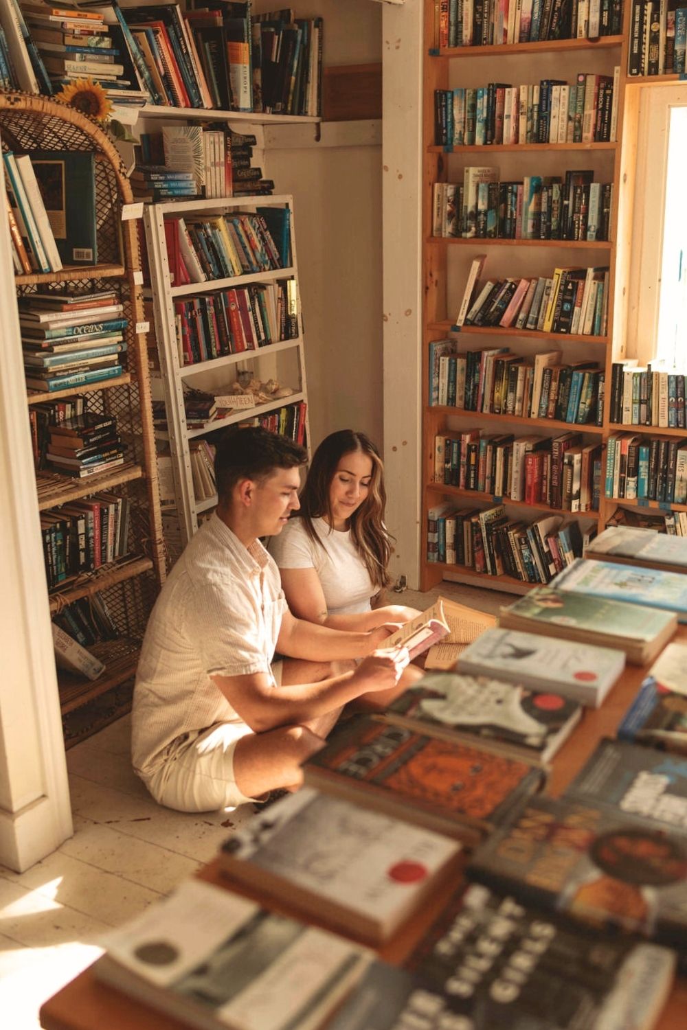 Sunrise bookstore portrait session Wolfe Island, ON. Couple surrounded by books in a tiny used book store. Wolfe Island Boat House.