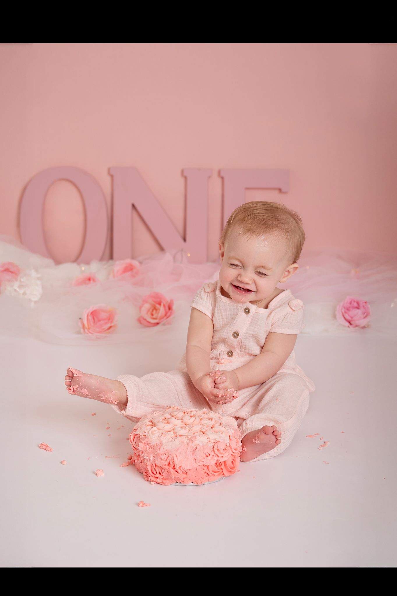 laughing girl age one with cake for first birthday