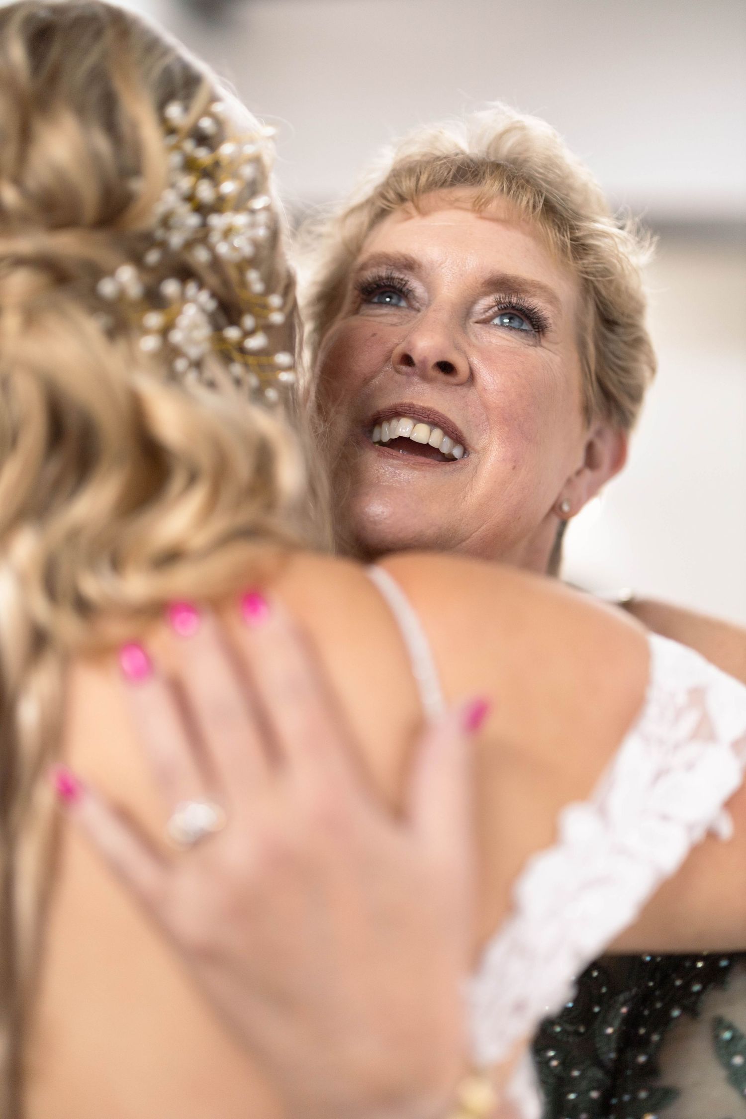 A joyful emotional moment between two people embracing during a wedding celebration.