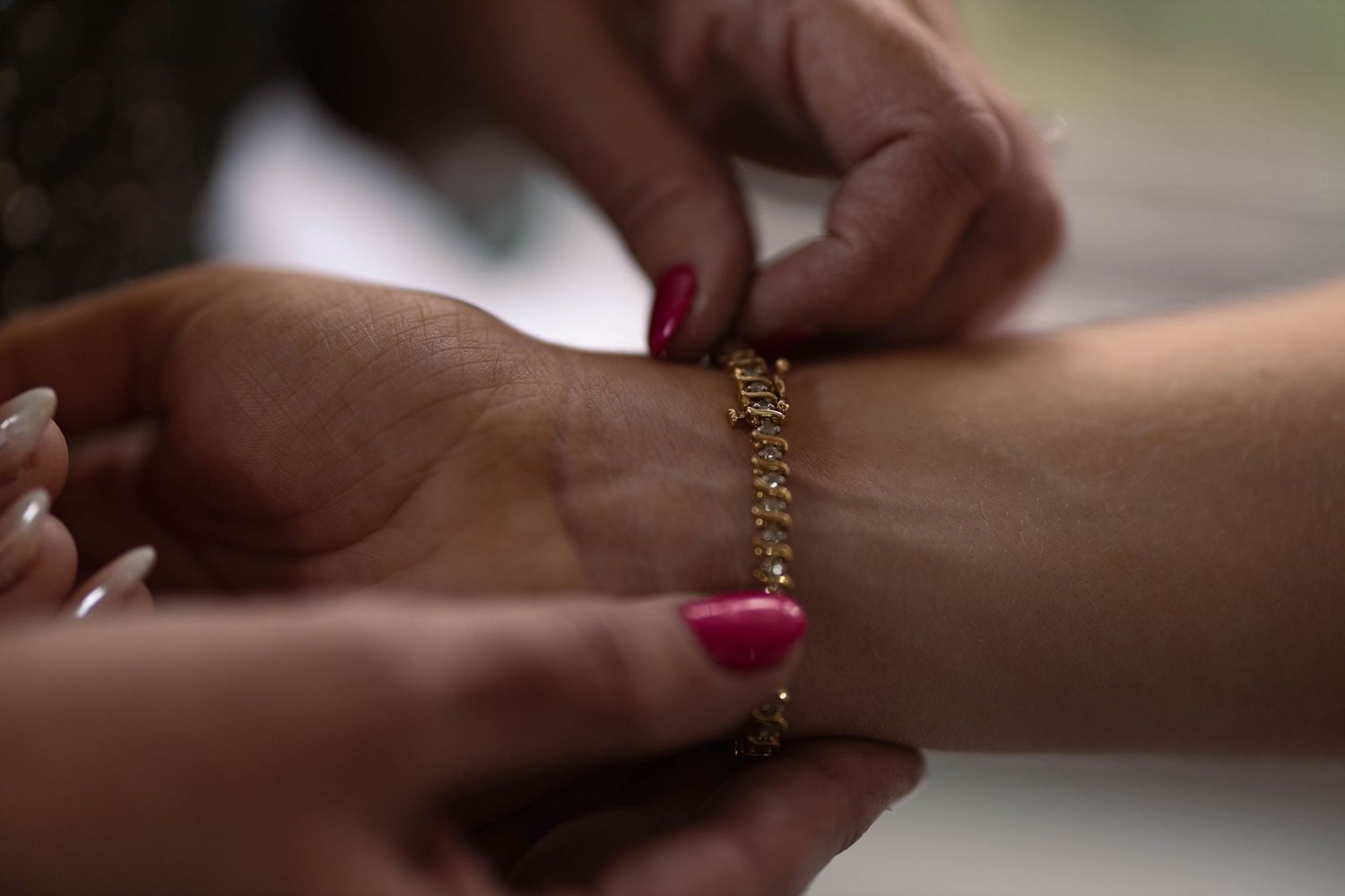 Professional manicurist applies nail polish to a client's fingernails in a salon setting.