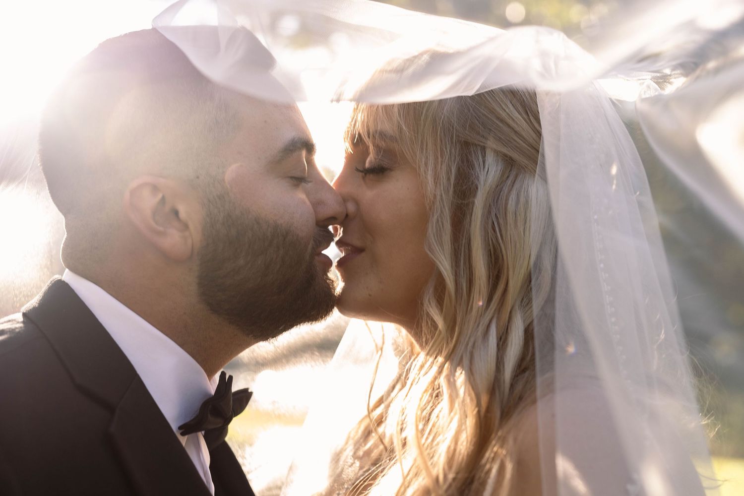 Romantic silhouettes of a bride and groom sharing intimate moments in soft sunlight.