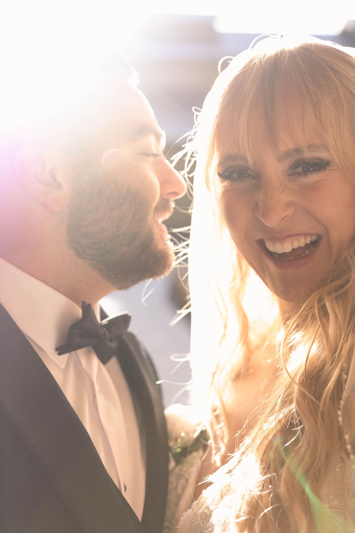 Backlit romantic wedding photo series showing joyful couple in golden sunlight creating an ethereal glow.