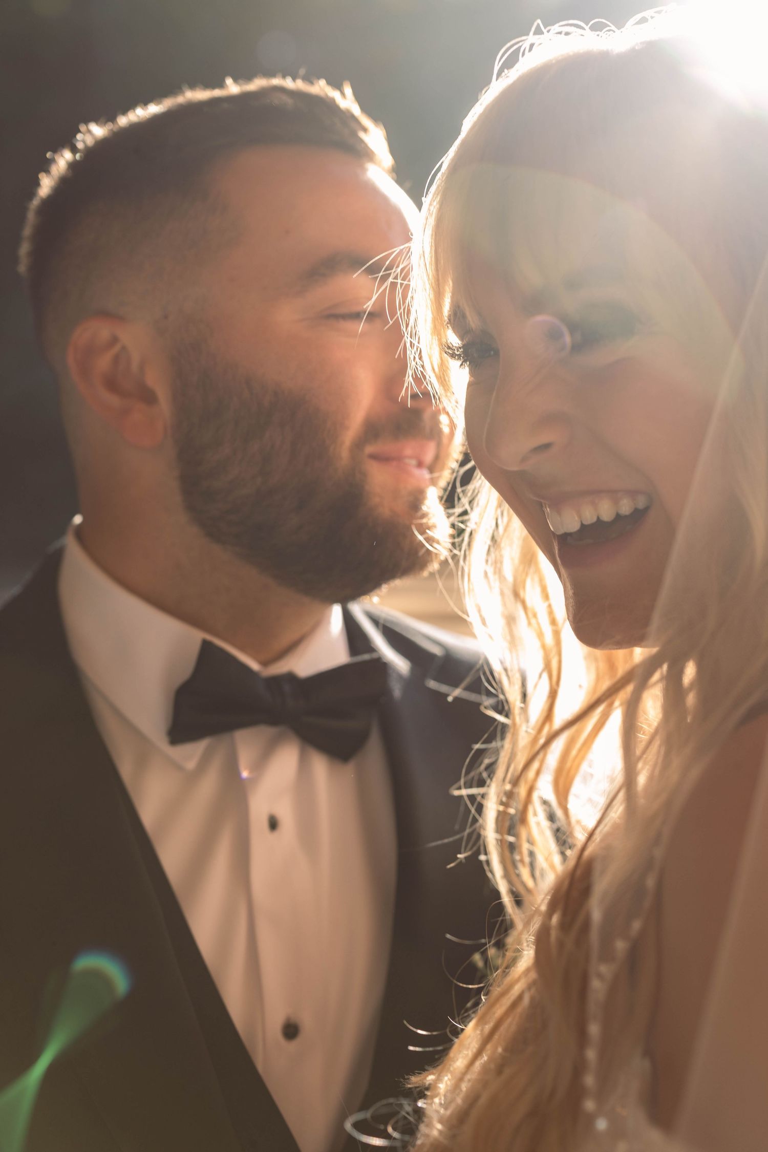 Close-up candid shots of newlywed couple laughing and sharing intimate moments in warm sunlit setting.