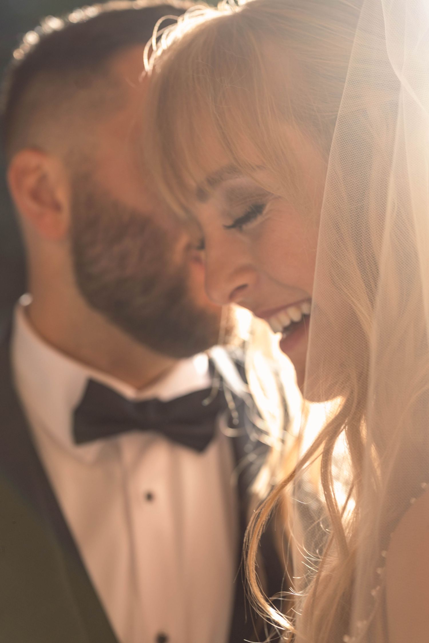 Romantic backlit portrait sequence of newlyweds in formal wear sharing intimate moments.