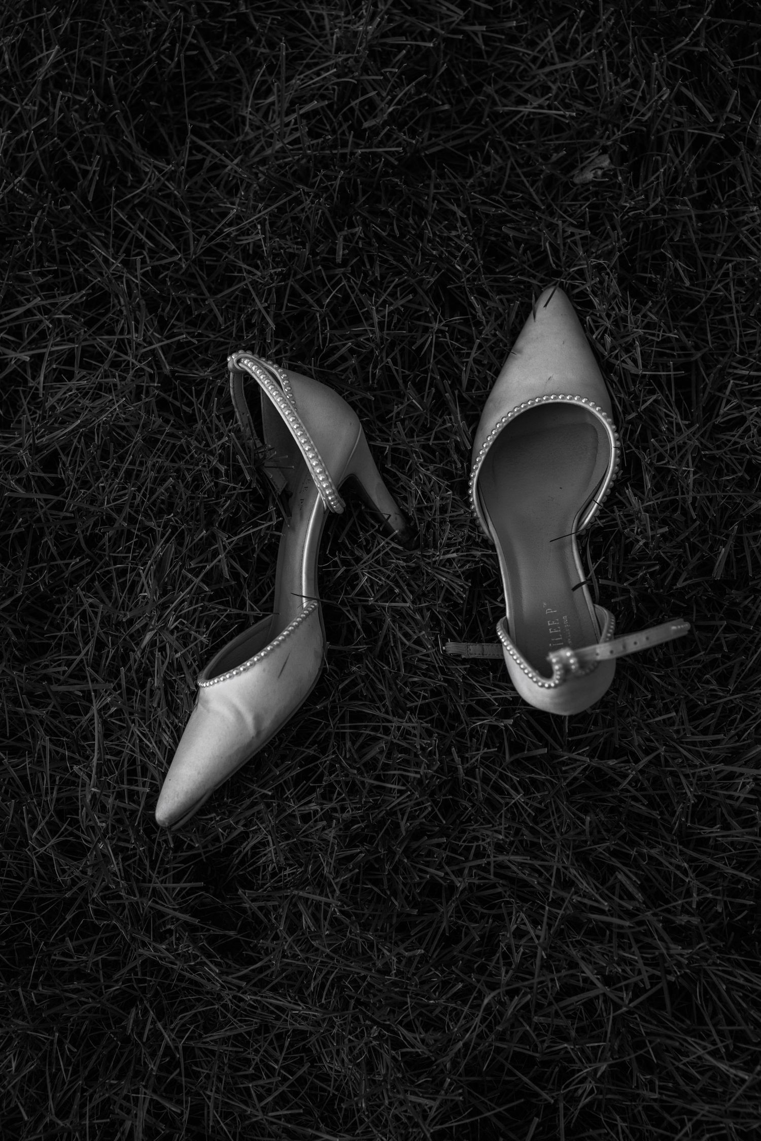 Black and white sequence of elegant bridal shoes against a dark background.