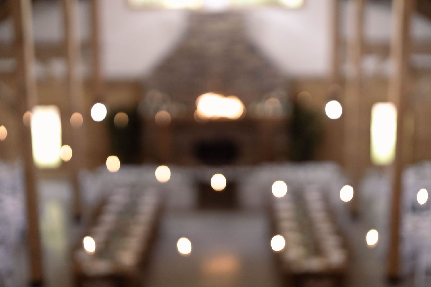 Bokeh lights create a dreamy atmosphere in a church interior with rows of pews visible in soft focus.