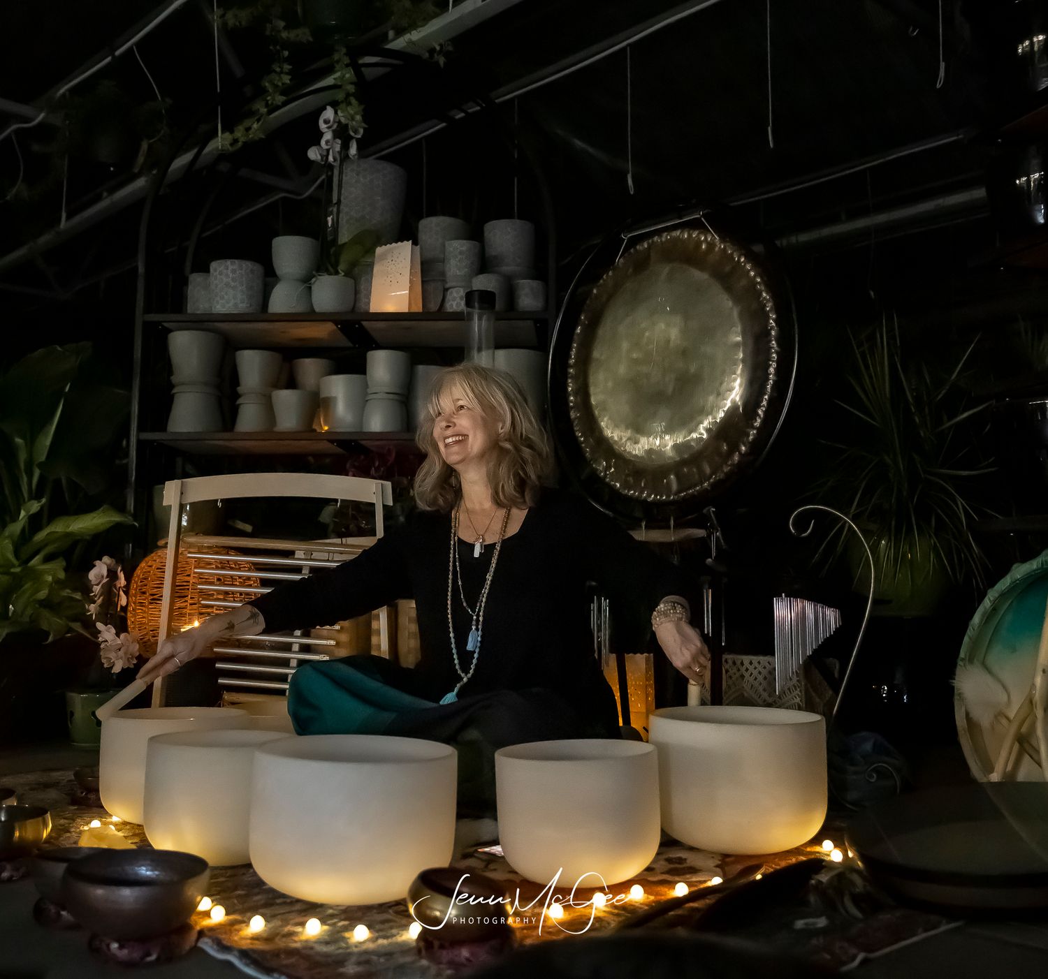 Collection of white ceramic bowls illuminated by string lights in dark setting.