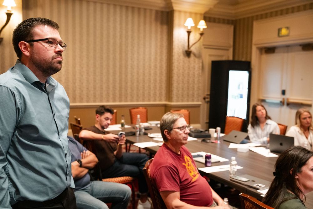 People sit attentively in a conference room during a business meeting or training session.